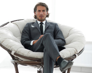 confident businessman sitting in a large comfortable chair.