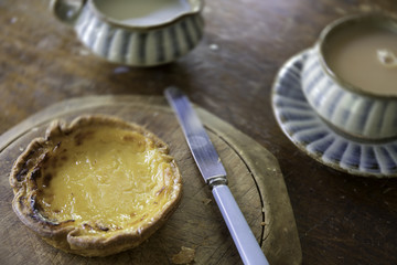 Portugese custard tart on wooden table top with Tea setting