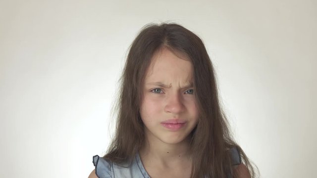 Beautiful sad teenage girl emotionally expresses pain and resentment close-up on white background stock footage video