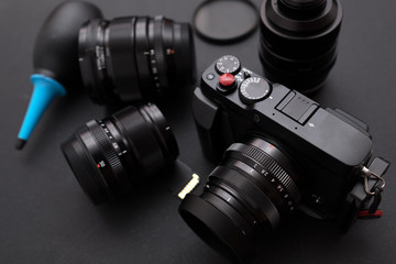 Digital mirrorless camera,prime lens ,super macro lens, lens filter and, dust blower on desk. concept of photographer work space