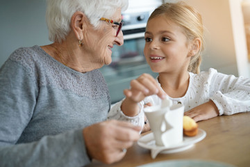 Obraz na płótnie Canvas Little girl having tea time with grandma