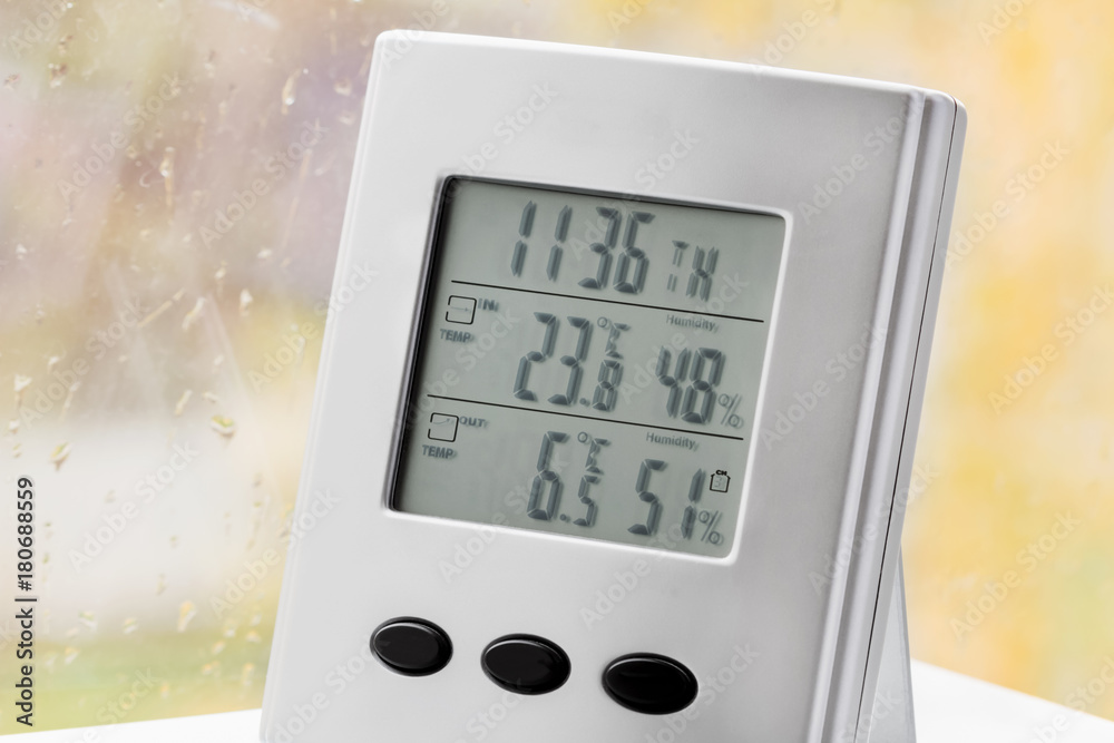 Wall mural weather station device with weather conditions inside and outside. background of a window with raind