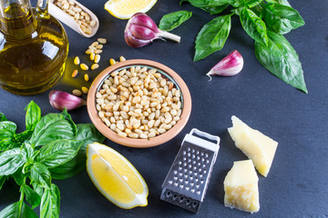 Green basil pesto sauce . Ingredients on black chalkboard background from above.