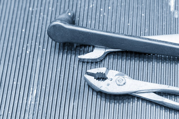The pliers and the wrench on the rubber table in the light tool.The tool for manufacturing process.