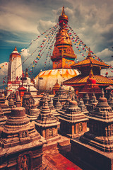 The famous Buddhist stupa at Boudanath in Kathmandu valley, Nepal. Was built in the 14th century. Blue cloudy sky in the background. Travel, holiday. Vintage retro toning filter orange color - obrazy, fototapety, plakaty