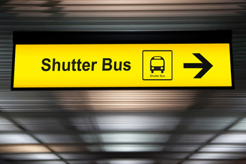 sign with arrow point to shuttle bus station at the airport for passenger who want to transfer from...