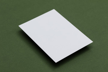 Blank white postcard on a green background