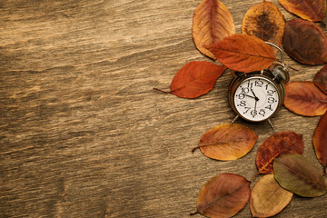 Old clock on a background of yellow leaves
