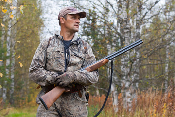 hunter with hunting gun in the woods
