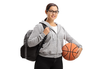 Teen girl with a backpack and a basketball