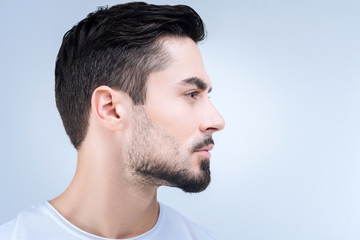 Nice haircut. Calm unemotional young man standing quietly and showing his new haircut after...