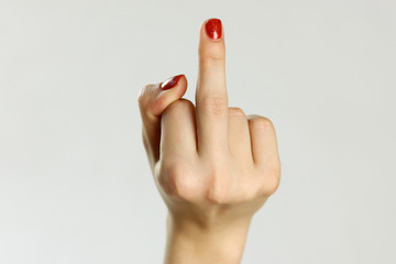 Female hand shows middle finger. Isolated on gray background. Closeup