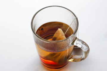 Transparent glass mug and a tea bag. A Cup of tea. Isolated on white background. Closeup
