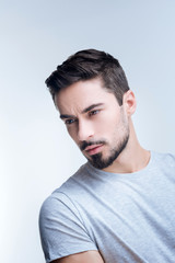 Fototapeta premium Unpleasant day. Serious tired young man feeling not ready to communicate with other people after having a difficult day at work