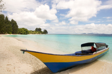 small boat in a tropical beach of raja ampat archipelago