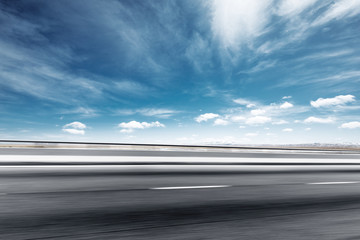 empty asphalt road with snow mountains in blue cloud sky
