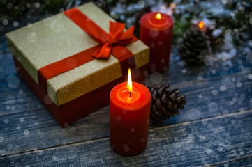 Burning candles and Christmas gift in a box. Background for the New Year's or Christmas card