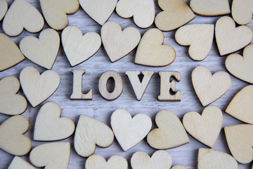 Obraz premium Heart shape from natural tree. Lovely heart shape by wooden small hearts on rustic wood table. Love theme concept with wooden hearts for Valentine's background and love theme.wooden leters i love you.