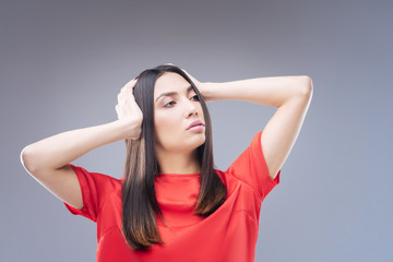 Fototapeta premium Tired passenger. Exhausted young passenger touching her head after spending too much time in the plane and feeling unwell and tired