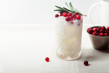 Perfect christmas cocktail: coconut margarita with cranberries and rosemary. Minimalistic concept. Linen cloth and white background. Horizontal composition with copy space.