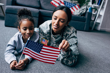 daughter and soldier with american flag