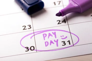 Fotobehang payday concept calendar with marker and circled day of salary © ronstik