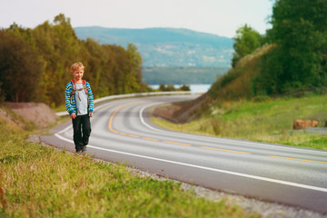 little tourist walking on the road with backpack, family travel