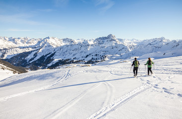 Two snowshoe hikers in alpine winter mountains. Bavaria, Germany.