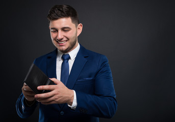 Elegant man in suit standing and checking his wallet