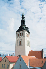 Saint Nicholas Church over red tiled roofs at Tallinn, Estonia on cloudy day.