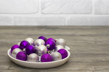 Silver and purple decorative balls on a gray background. Concept of the Christmas and new year.