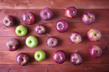 Top view of red and green ripe apples on wooden background