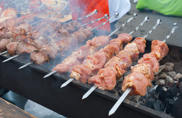 Pieces of meat on skewers are roasted on hot coals.