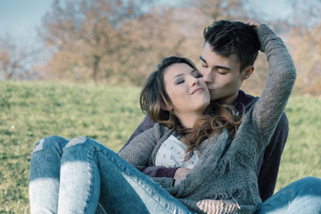 Fototapeta premium Smiling young couple sitting on the grass