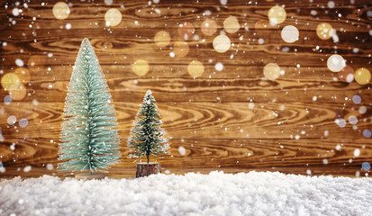 Old wooden planks with christmas trees. Brown background with snow and snowflakes