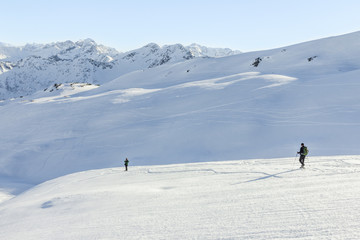 Two snowshoe hikers in alpine winter mountains. Bavaria, Germany.