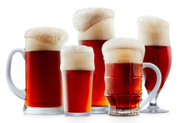 Mug of frosty dark red beer with foam isolated on a white background