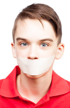 Speechless teen boy  with tape over his mouth