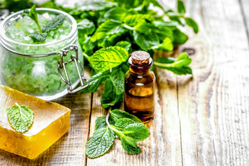 organic cosmetics with herbal extracts of mint on wooden backgro