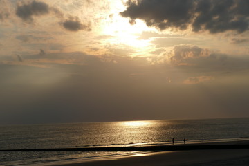 Einsame Menschen am Strand bei Sonnenuntergang