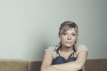 Naklejka premium Woman Suffering From Depression Sitting On Bed And Crying