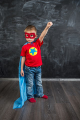 Obraz na płótnie Canvas boy superhero in a blue Cape red mask and a red t-shirt with a star