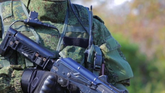 Soldier with automatic rifle. Closeup. Front view