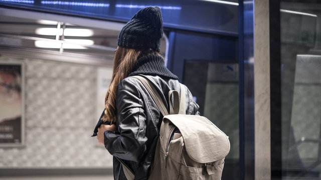 Young woman passenger in public train station in city