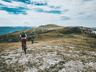 Fototapeta premium man riding the bike in the mountains with the kid