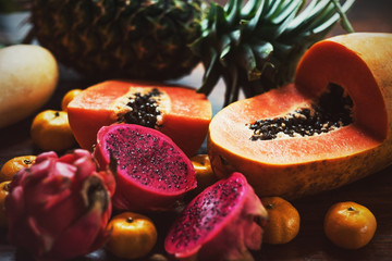 Juicy exotic fruits close up. Pineapple, papaya, mango, gragon fruit on table ready to eat