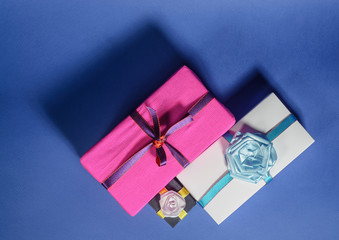 Set of multicolored gift boxes with bows on a blue background. top view