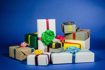 Set of multicolored gift boxes with bows on a blue background