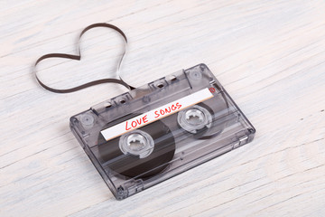 Audio cassette tape on wooden background. audio film shaping heart