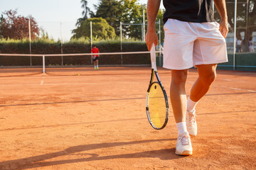 Fototapeta na wymiar Unrecognizable professional tennis player walking on tennis court on sunny day. 